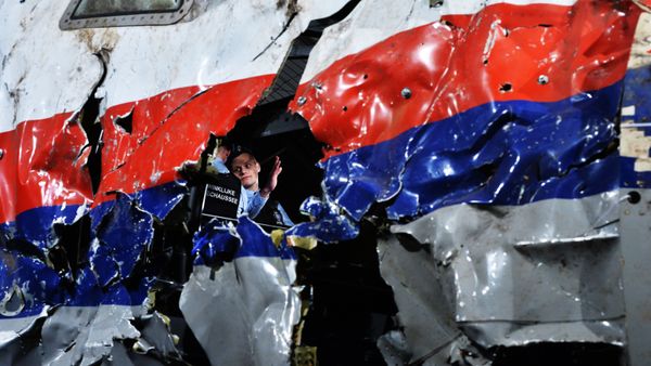 Часть реконструированного сбитого лайнера Boeing 777 Malaysia Airlines рейса MH17 во время доклада об обстоятельствах его крушения на Востоке Украины 17 июля 2014 года на военной базе Гилзе-Рейен в Нидерландах Часть реконструированного сбитого лайнера Boeing 777 Malaysia Airlines рейса MH17 во время доклада об обстоятельствах его крушения на Востоке Украины 17 июля 2014 года на военной базе Гилзе-Рейен в Нидерландах - Sputnik International