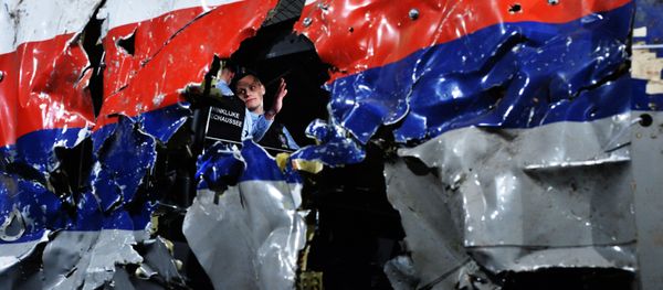 Часть реконструированного сбитого лайнера Boeing 777 Malaysia Airlines рейса MH17 во время доклада об обстоятельствах его крушения на Востоке Украины 17 июля 2014 года на военной базе Гилзе-Рейен в Нидерландах Часть реконструированного сбитого лайнера Boeing 777 Malaysia Airlines рейса MH17 во время доклада об обстоятельствах его крушения на Востоке Украины 17 июля 2014 года на военной базе Гилзе-Рейен в Нидерландах - Sputnik International