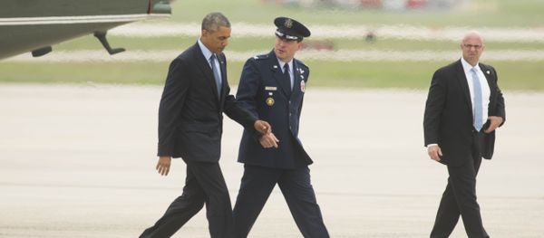 President Barack Obama talks with Col. Dave Siegrist, right, as they walk to Air Force One. - Sputnik International