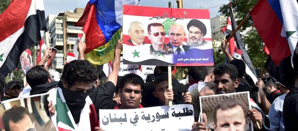 Syrians, living in Lebanon, carry banners as they wave Russian and Syrian national flags to express their support to Syria's President Bashar al-Assad and to thank Russia for its operation in Syria, outside the Russian embassy in Beirut, Lebanon, October 18, 2015 - Sputnik International