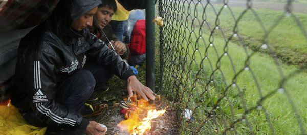 Migrants burn shoes in a bonfire to warm themselves up as they wait at the border with Slovenia in Trnovec, Croatia, October 19, 2015. - Sputnik International