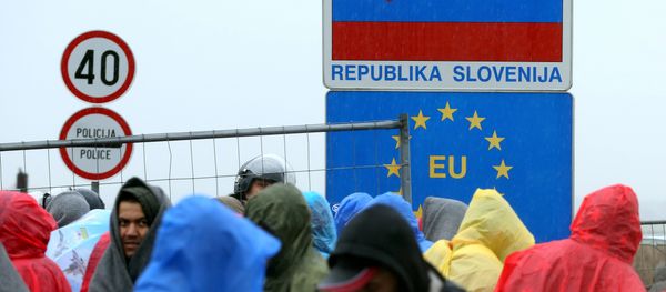 Migrants and refugees wait in the rain as they wait to enter Slovenia, at the Croatian-Slovenian border in Trnovec, on October 19, 2015. Migrants and refugees wait in the rain as they wait to enter Slovenia, at the Croatian-Slovenian border in Trnovec, on October 19, 2015. - Sputnik International
