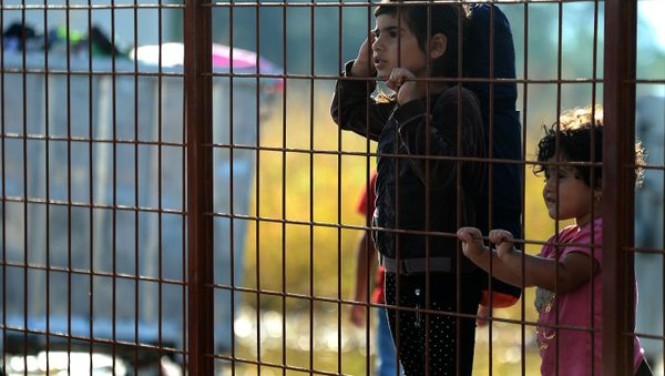 Children wait behind a fence to pass with their families in the southern Macedonian town of Gevgelija, Friday, Sept. 11, 2015. - Sputnik International