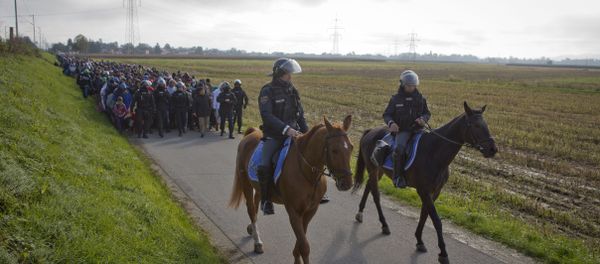 Policemen ride on their horses in front of migrants after they crossed from Croatia, in Dobova, near a border crossing between Croatia and Slovenia Tuesday, Oct. 20, 2015. - Sputnik International
