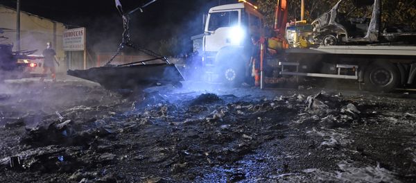 A man operates a crate, lifting up debris of burnt cars following a series of violent incidents on October 20, 2015 in Moirans, near Grenoble - Sputnik International