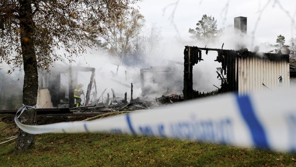 A firefighter works to extinguish a fire that broke out early in the morning at an accommodation for asylum seekers, near Munkedal in Sweden October 20, 2015 - Sputnik International