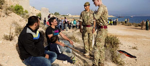 In this photo released by the British Forces in Cyprus on Wednesday, Oct. 21, 2015, British soldiers stand and talk with two of the 114 migrants at the British air forces in Akrotiri near southern coastal city of Limassol, Cyprus. In this photo released by the British Forces in Cyprus on Wednesday, Oct. 21, 2015, British soldiers stand and talk with two of the 114 migrants at the British air forces in Akrotiri near southern coastal city of Limassol, Cyprus. - Sputnik International