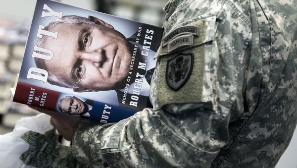 A soldier waits to have his copy of DUTY: Memoirs of a Secretary of War by Robert M. Gates, signed by former Secretary Gates at the Pentagon January 16, 2014 in Washington, DC - Sputnik International