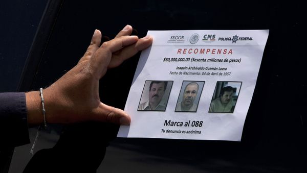A Federal Police presses on a reward notice for information leading to the capture of drug lord Joaquin El Chapo Guzman, who made his escape from the Altiplano maximum security prison via an underground tunnel, in Almoloya, west of Mexico City, Thursday, July 16, 2015 A Federal Police presses on a reward notice for information leading to the capture of drug lord Joaquin El Chapo Guzman, who made his escape from the Altiplano maximum security prison via an underground tunnel, in Almoloya, west of Mexico City, Thursday, July 16, 2015 - Sputnik International