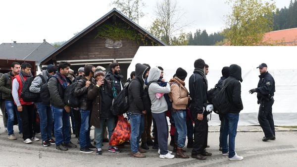German police officer instructs migrants ahead of their walk from the Austrian-German border to a first registration point of the German federal police in the small Bavarian village Wegscheid, southern Germany, on October 20, 2015 German police officer instructs migrants ahead of their walk from the Austrian-German border to a first registration point of the German federal police in the small Bavarian village Wegscheid, southern Germany, on October 20, 2015 - Sputnik International