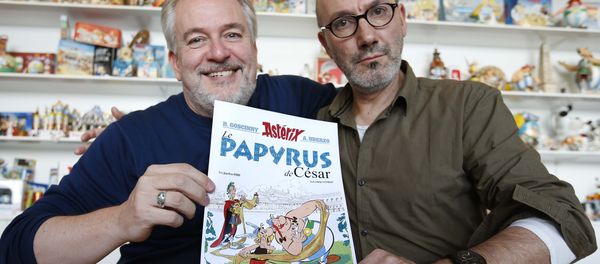 Author Jean-Yves Ferri (R) and illustrator Didier Conrad (L) pose with a print of the cover of their new comic book Le Papyrus de Cesar (Asterix and the Missing Scroll) in Vanves, Southern Paris, France, October 13, 2015 - Sputnik International
