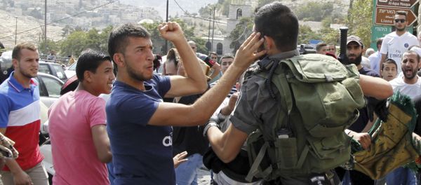 An Israeli border policeman exchanges blows with a Palestinian man during a confrontation after Friday prayers outside the Old City in Jerusalem Friday, Oct. 2, 2015 - Sputnik International
