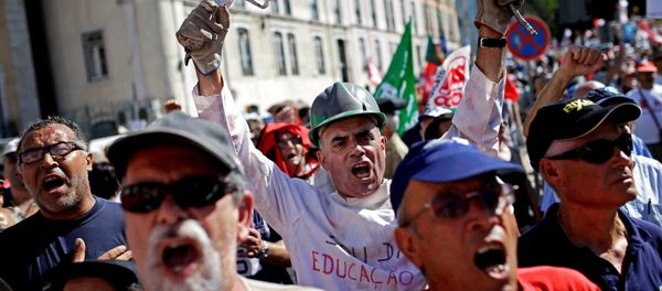 People shout slogans outside the Portuguese parliament during a protest by Portugal's main union CGTP, General Confederation of the Portuguese Workers, against cuts in salaries and pensions and others austerity measures taken by the government, in Lisbon, Thursday, July 10, 2014. - Sputnik International
