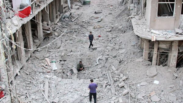 People walk on the rubble of damaged buildings after Syrian military helicopter allegedly droped barrel bombs over the city of Daraya, southwest of the capital Damascus - Sputnik International