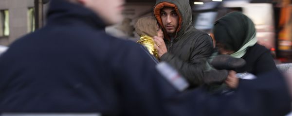 Members of a Syrian family stand in a street as migrants and refugees are evicted by French police from a camp at the Porte de Saint-Ouen in Paris early on October 2, 2015 - Sputnik International
