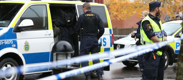 Police officers stand guard at a cordoned area after a masked man attacked people with a sword at a school in Trollhattan, western Sweden October 22, 2015 - Sputnik International