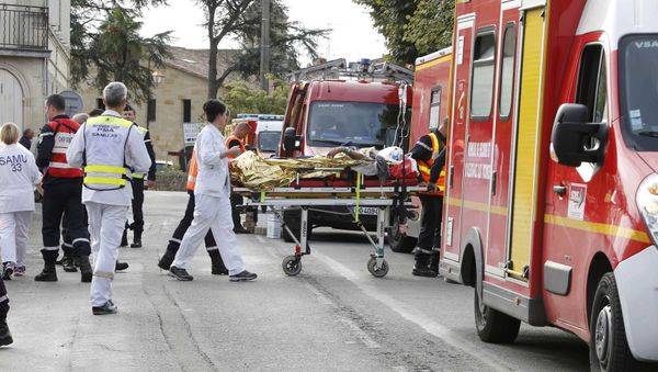 Rescue workers carry a injured person on a stretcher during rescue operations near the site where a coach carrying members of an elderly people's club collided with a truck outside Puisseguin near Bordeaux, western France, October 23, 2015 - Sputnik International