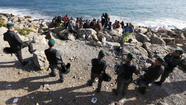 Migrants wait on the rocks on the shoreline under the surveillance of policemen on September 30, 2015 at the French-Italian border in Ventimiglia Migrants wait on the rocks on the shoreline under the surveillance of policemen on September 30, 2015 at the French-Italian border in Ventimiglia - Sputnik International