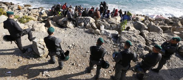Migrants wait on the rocks on the shoreline under the surveillance of policemen on September 30, 2015 at the French-Italian border in Ventimiglia Migrants wait on the rocks on the shoreline under the surveillance of policemen on September 30, 2015 at the French-Italian border in Ventimiglia - Sputnik International