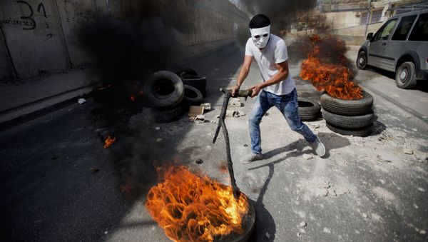 Palestinians burn tires front of Israel's separation barrier during clashes with Israeli troops for a tensions over a sensitive Jerusalem holy site, in the West Bank town of al-Ram, north of Jerusalem, Thursday, Oct. 22, 2015 Palestinians burn tires front of Israel's separation barrier during clashes with Israeli troops for a tensions over a sensitive Jerusalem holy site, in the West Bank town of al-Ram, north of Jerusalem, Thursday, Oct. 22, 2015 - Sputnik International