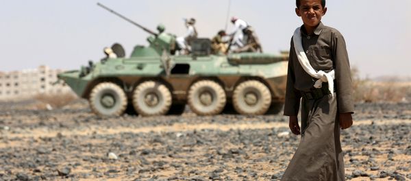 A boy walks in front of fighters of the Popular Resistance Committees riding on an armored vehicle during a ceremony where they formally take over territory that the government had managed to recover from Houthi militants, in the central province of Marib October 11, 2015. A boy walks in front of fighters of the Popular Resistance Committees riding on an armored vehicle during a ceremony where they formally take over territory that the government had managed to recover from Houthi militants, in the central province of Marib October 11, 2015. - Sputnik International