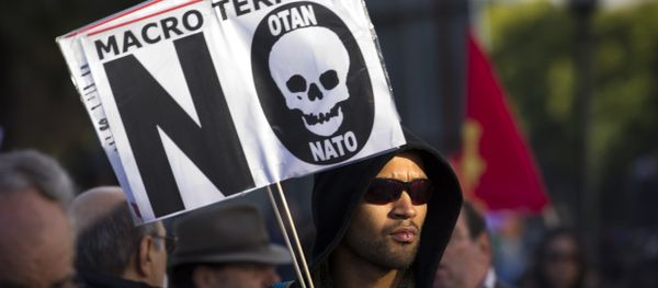 A protester holds a sign that reads Macro terror, no to NATO during a demonstration against NATO in Lisbon, on Saturday, Nov. 20, 2010 A protester holds a sign that reads Macro terror, no to NATO during a demonstration against NATO in Lisbon, on Saturday, Nov. 20, 2010 - Sputnik International