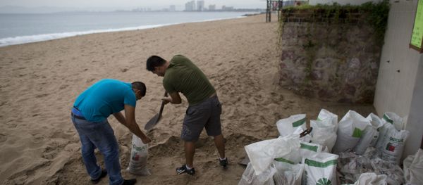 Men fill small bags with sand from the beach as they prepare for the arrival of Hurricane Patricia in Puerto Vallarta. - Sputnik International