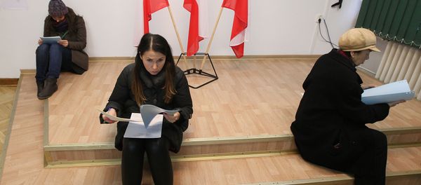 Voters read documents during the first round of Polish local elections in Warsaw, Poland, Sunday, Nov. 16, 2014 - Sputnik International