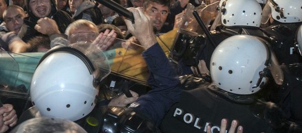 A riot policeman hits Montenegro's opposition leader Nebojsa Medojevic (facing camera, on R of baton) with a baton while dispersing protesters outside the parliament building in the capital Podgorica, Montenegro, October 17, 2015 - Sputnik International