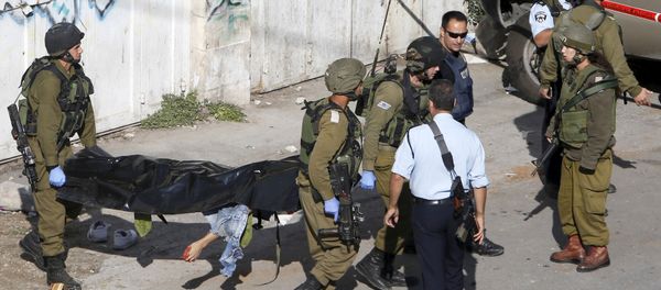 Israeli soldiers carry the body of a Palestinian, who Israeli police and army said stabbed a soldier, after he was shot by an Israeli policeman, in the West Bank old city of Hebron October 29, 2015 - Sputnik International