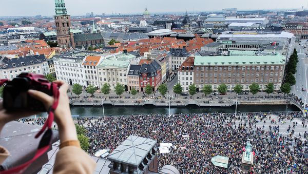 A photographer takes a photo of some 30,000 people who joined a rally in Copenhagen on September 12, 2015 in favour of taking in thousands of refugees seeking shelter in Europe, police said - Sputnik International
