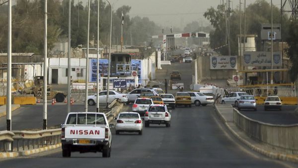 Iraqi security forces stand guard as vehicles move toward the gate of the heavily fortified Green Zone in Baghdad, Iraq, Monday, Oct. 5, 2015 - Sputnik International