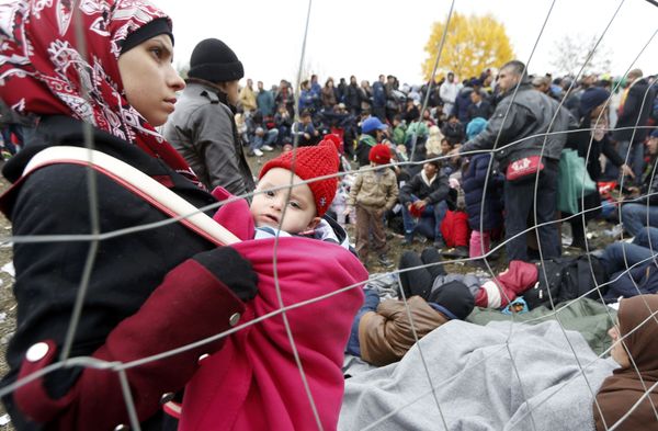 A woman holds a baby as migrants queue to cross the border into Spielfeld in Austria from the village of Sentilj, Slovenia, October 28, 2015. - Sputnik International