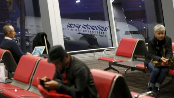 Passengers wait for their flight at the departure area of Boryspil International Airport as an airplane from Ukrainian International Airlines is seen in the background outside Kiev, Ukraine, October 24, 2015 - Sputnik International