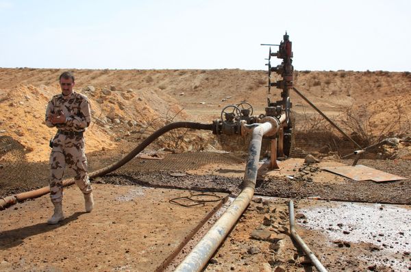 A member of the Syrian government forces walks next to a well at Jazel oil field, near the ancient city of Palmyra in the east of Homs province after they retook the area from Islamic State (IS) group fighters on March 9, 2015. - Sputnik International