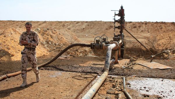 A member of the Syrian government forces walks next to a well at Jazel oil field, near the ancient city of Palmyra in the east of Homs province after they retook the area from Islamic State (IS) group fighters on March 9, 2015 - Sputnik International