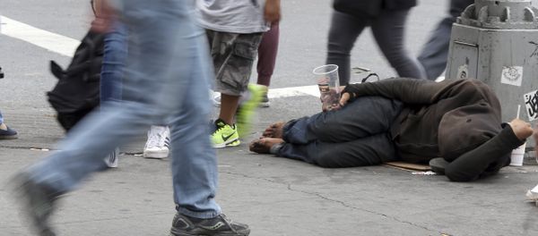 People walk past a homeless man asking for money on 14th Street, Friday, Sept. 4, 2015, in New York - Sputnik International