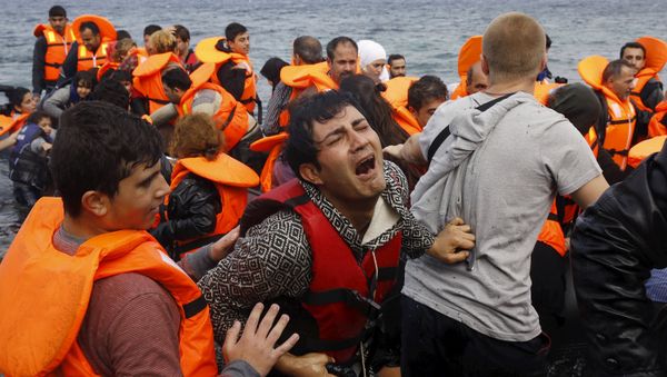 A Syrian refugee cries while disembarking from a flooded raft at a beach on the Greek island of Lesbos, after crossing a part of the Aegean Sea from the Turkish coast on an overcrowded raft, October 20, 2015 A Syrian refugee cries while disembarking from a flooded raft at a beach on the Greek island of Lesbos, after crossing a part of the Aegean Sea from the Turkish coast on an overcrowded raft, October 20, 2015 - Sputnik International