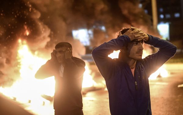 People react as smoke billows from burning pallets set on fire during clashes between Turkish riot policemen and Kurdish protesters in the southeastern city of Diyarbakir on November 1, 2015 after first results of the Turkish general election showed a clear victory to the Justice and Development Party (AKP). Turkish police fired tear gas and water cannon at Kurds who were protesting after the election appeared to deliver a clear victory to AKP, an AFP photographer said. Latest results say the pro-Kurdish People's Democratic Party (HDP) won slightly over 10 percent of the vote, just enough to scrape into parliament. - Sputnik International