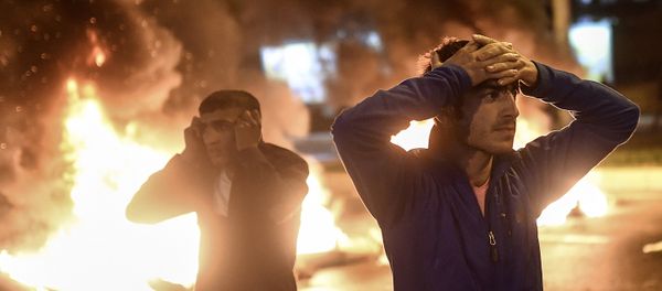 People react as smoke billows from burning pallets set on fire during clashes between Turkish riot policemen and Kurdish protesters in the southeastern city of Diyarbakir on November 1, 2015 after first results of the Turkish general election showed a clear victory to the Justice and Development Party (AKP). Turkish police fired tear gas and water cannon at Kurds who were protesting after the election appeared to deliver a clear victory to AKP, an AFP photographer said. Latest results say the pro-Kurdish People's Democratic Party (HDP) won slightly over 10 percent of the vote, just enough to scrape into parliament. People react as smoke billows from burning pallets set on fire during clashes between Turkish riot policemen and Kurdish protesters in the southeastern city of Diyarbakir on November 1, 2015 after first results of the Turkish general election showed a clear victory to the Justice and Development Party (AKP). Turkish police fired tear gas and water cannon at Kurds who were protesting after the election appeared to deliver a clear victory to AKP, an AFP photographer said. Latest results say the pro-Kurdish People's Democratic Party (HDP) won slightly over 10 percent of the vote, just enough to scrape into parliament. - Sputnik International