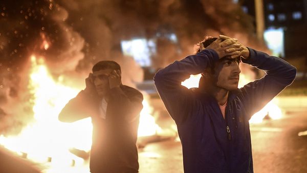 People react as smoke billows from burning pallets set on fire during clashes between Turkish riot policemen and Kurdish protesters in the southeastern city of Diyarbakir on November 1, 2015 after first results of the Turkish general election showed a clear victory to the Justice and Development Party (AKP). Turkish police fired tear gas and water cannon at Kurds who were protesting after the election appeared to deliver a clear victory to AKP, an AFP photographer said. Latest results say the pro-Kurdish People's Democratic Party (HDP) won slightly over 10 percent of the vote, just enough to scrape into parliament. People react as smoke billows from burning pallets set on fire during clashes between Turkish riot policemen and Kurdish protesters in the southeastern city of Diyarbakir on November 1, 2015 after first results of the Turkish general election showed a clear victory to the Justice and Development Party (AKP). Turkish police fired tear gas and water cannon at Kurds who were protesting after the election appeared to deliver a clear victory to AKP, an AFP photographer said. Latest results say the pro-Kurdish People's Democratic Party (HDP) won slightly over 10 percent of the vote, just enough to scrape into parliament. - Sputnik International