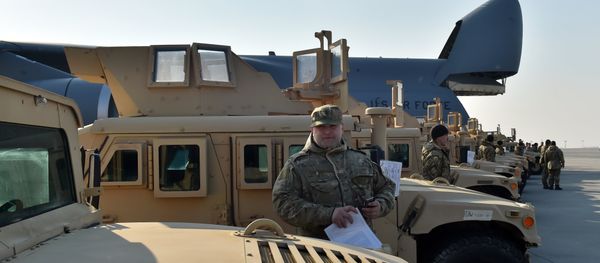 A Ukrainian serviceman holds a certificate at he stands next to an armoured car at Kiev airport on March 25, 2015 during a welcoming ceremony of the first US plane delivery of non-lethal aid, including 10 Humvee vehicles - Sputnik International