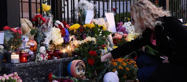 A woman lays flowers at the Russian Embassy in Kiev to mourn the victims of Kogalymavia's Airbus A321 passenger airliner - Sputnik International