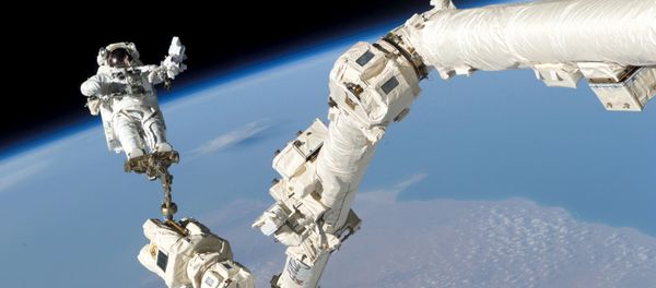 Astronaut Stephen K. Robinson, STS-114 mission specialist, anchored to a foot restraint on the International Space Station's Canadarm2, participates in the mission's third session of extravehicular activity (EVA) August 3, 2005 - Sputnik International