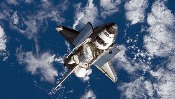 This handout provided by NASA, backdropped by a blue and white Earth, shows US Space Shuttle Discovery approaching the International Space Station during STS-120 rendezvous and docking operations 25 October 2007 - Sputnik International