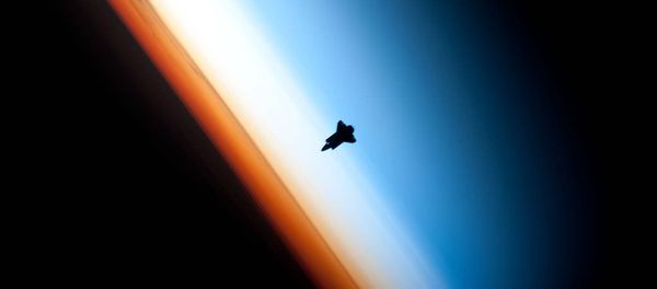 In a very unique setting over Earth's colorful horizon, the silhouette of the space shuttle Endeavour is featured in this photo by an Expedition 22 crew member on board the International Space Station, as the shuttle approached for its docking on Feb. 9 during the STS-130 mission. - Sputnik International