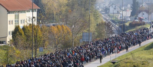 Migrants and refugee are escorted by Slovenian police officers toward the Slovenian-Austrian border crossing in Sentilj, Slovenia, Saturday, Oct. 31, 2015. - Sputnik International