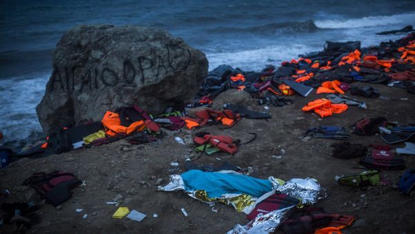 The body of a young man covered with a blue blanket remains on Eftalou beach after his dinghy capsized on the northeastern Greek island of Lesbos, Friday, Oct. 30, 2015. The body of a young man covered with a blue blanket remains on Eftalou beach after his dinghy capsized on the northeastern Greek island of Lesbos, Friday, Oct. 30, 2015. - Sputnik International