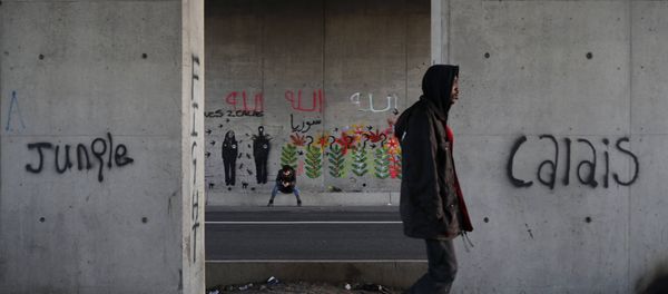 Migrants make their way along a road near graffiti with the words Jungle, Calais in Calais, France, October 20, 2015. Migrants make their way along a road near graffiti with the words Jungle, Calais in Calais, France, October 20, 2015. - Sputnik International