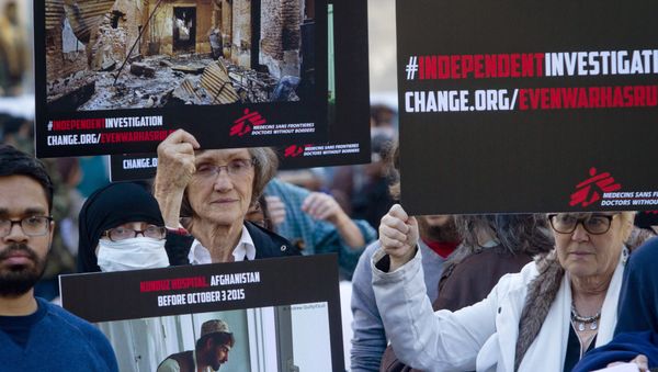 Supporters of Doctors Without Borders hold before and after images during a rally to mark the one-month anniversary of a U.S. military strike on its trauma center in Afghanistan. - Sputnik International